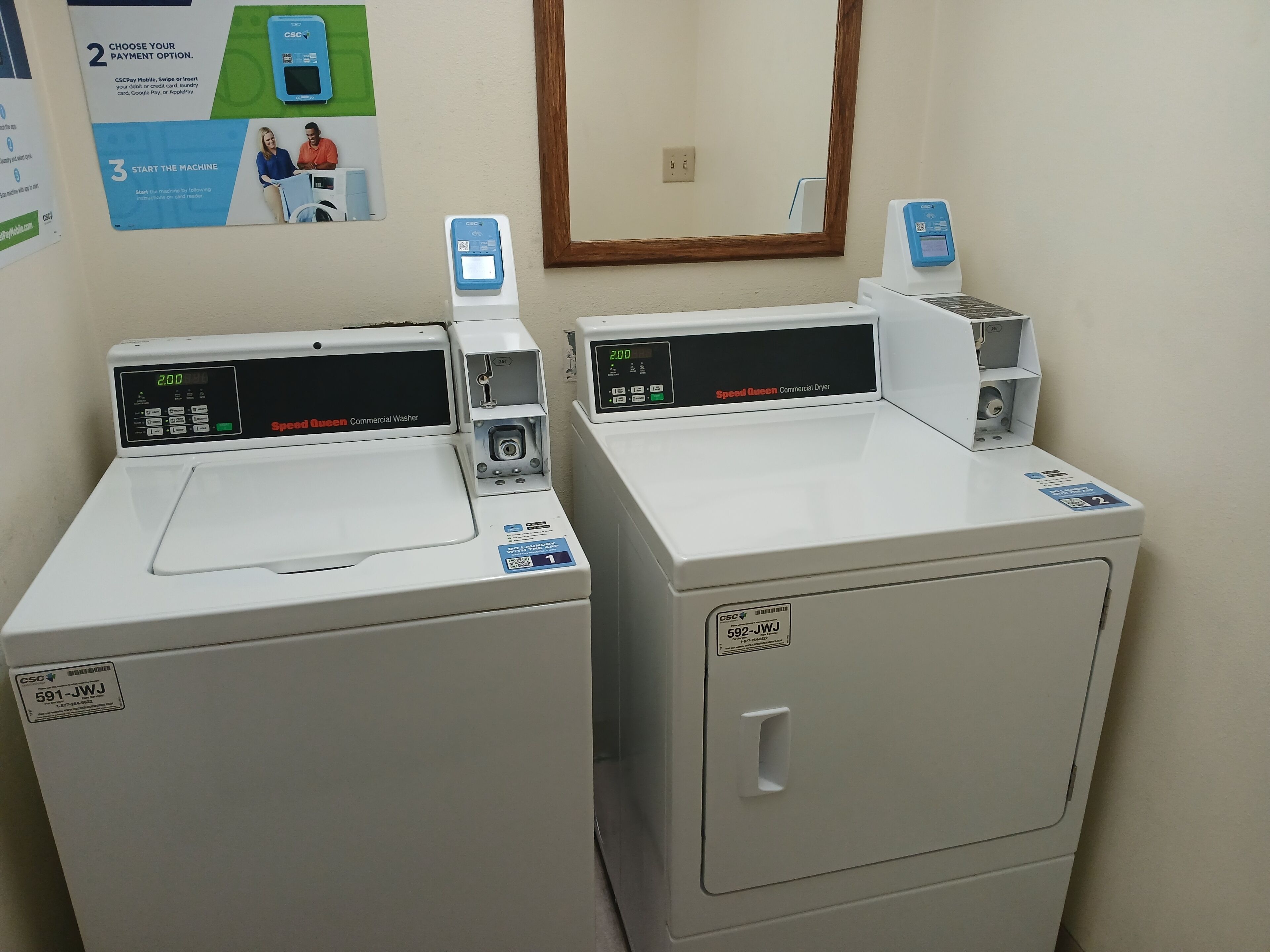 Two commercial washers with digital displays and payment options.