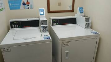 Two commercial washers with digital displays and payment options.