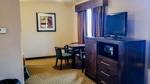 A hotel room with a desk, chair, television, and a framed artwork on the wall. - Inn America - Lewiston (Lewiston)