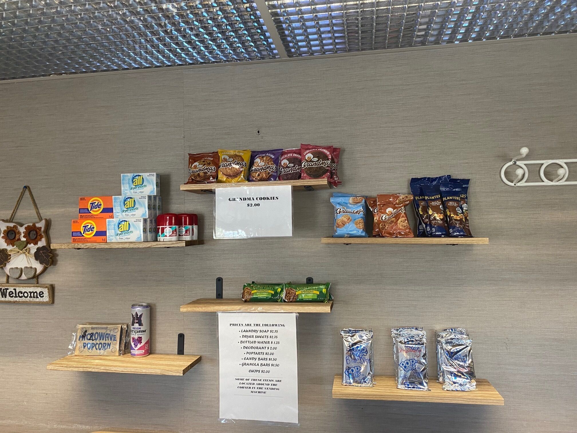 Interior de una tienda con estantes mostrando diversos productos como galletas, aperitivos y artículos de limpieza.