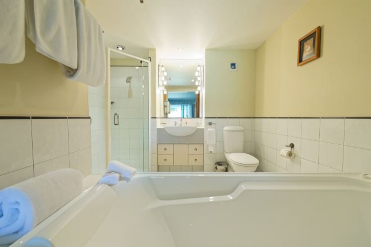 Un baño con bañera, inodoro y zona de ducha.