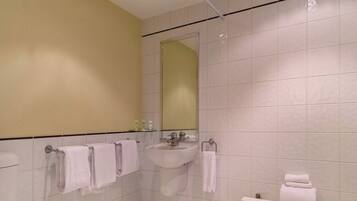 Un baño moderno con inodoro, lavamanos y zona de ducha.