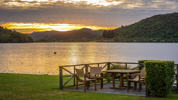 Un espace aménagé au bord du lac, offrant une vue sur le coucher de soleil sur l’eau.