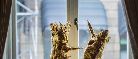 Una ventana con dos estatuas doradas de animales.