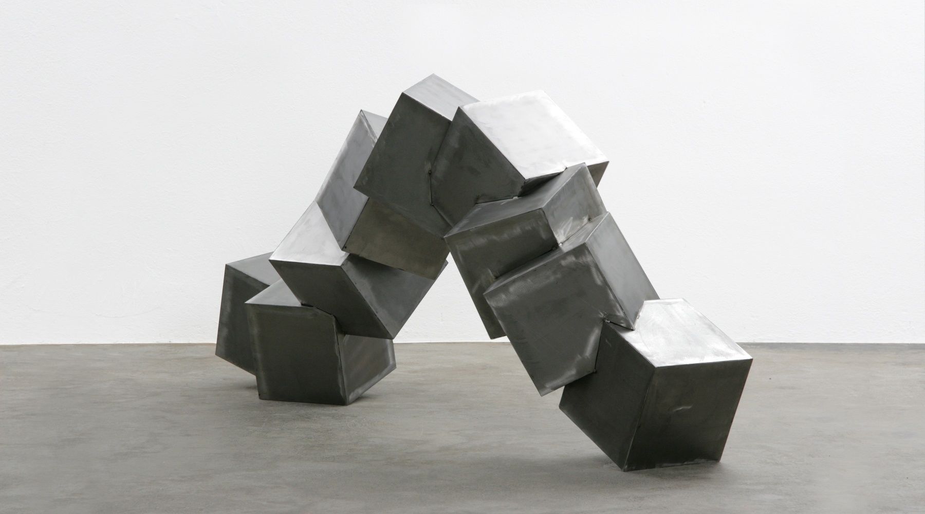 A geometric metal sculpture in an indoor setting.