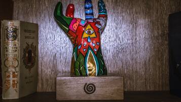 En hylla i trä med en färgstark skulptur formad som en hand och en bok med titeln "Vor Sidsste Kamp for Sondersyldland" av Axel Liljerup.