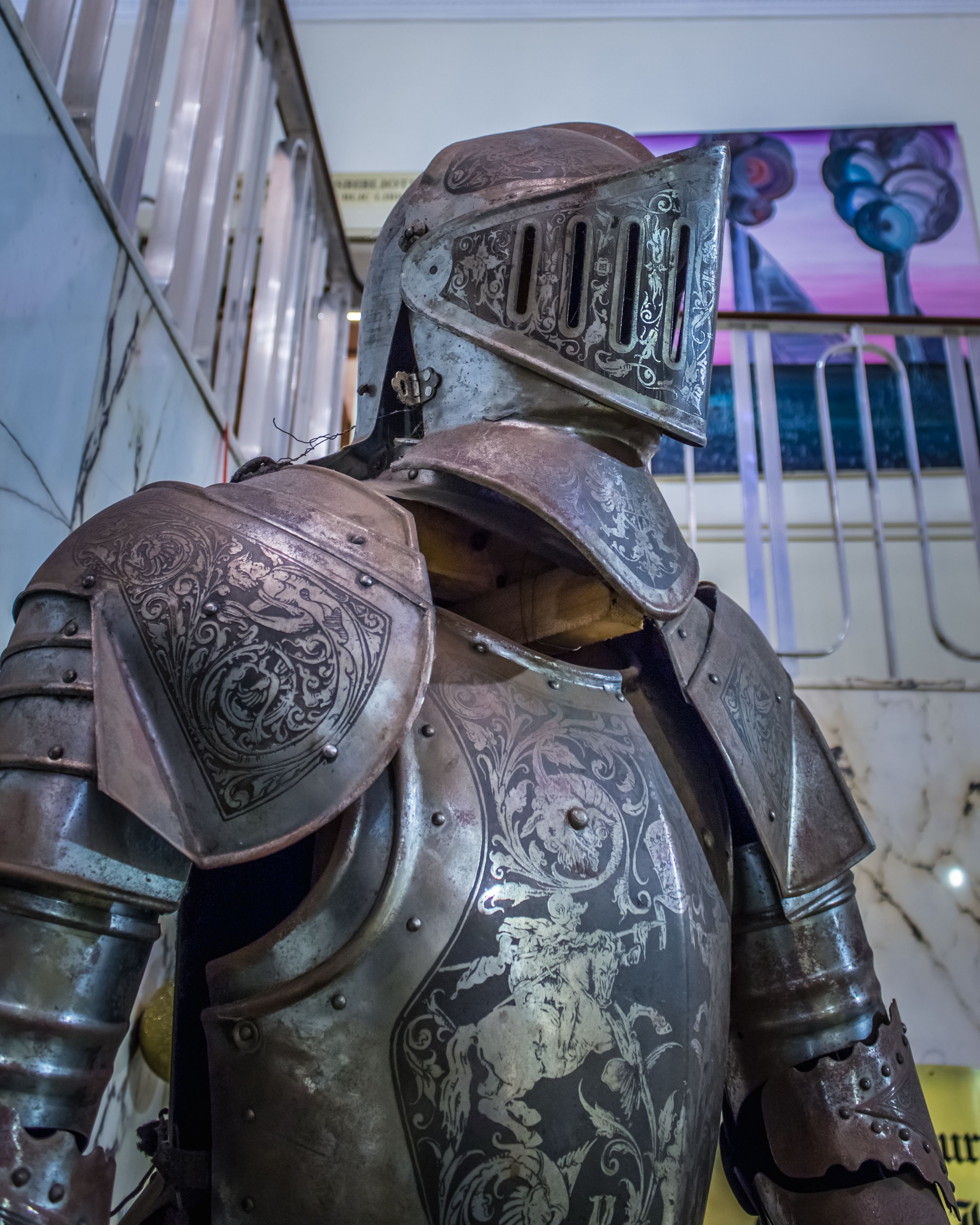 Ritterrüstung aus dem Mittelalter mit aufwendigen Verzierungen und einem Helm mit Visiermasche.