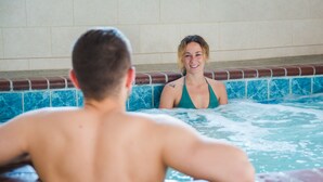A person in a hot tub with a tiled wall in the background. - Seashore Inn on the Beach (Seaside)