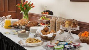 A breakfast buffet with various food items, including pastries, fruits, and beverages.