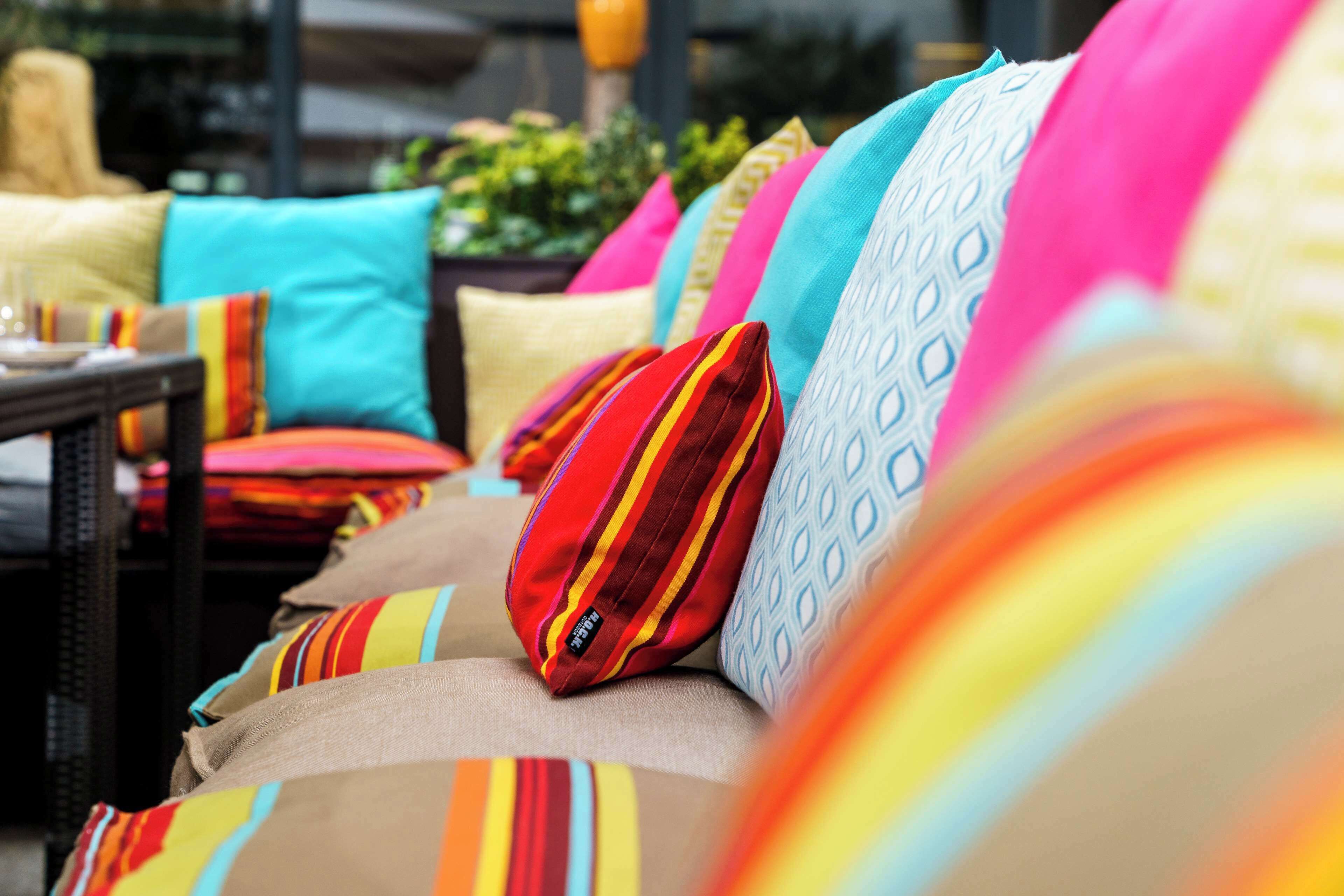 A row of sofas with colorful cushions.