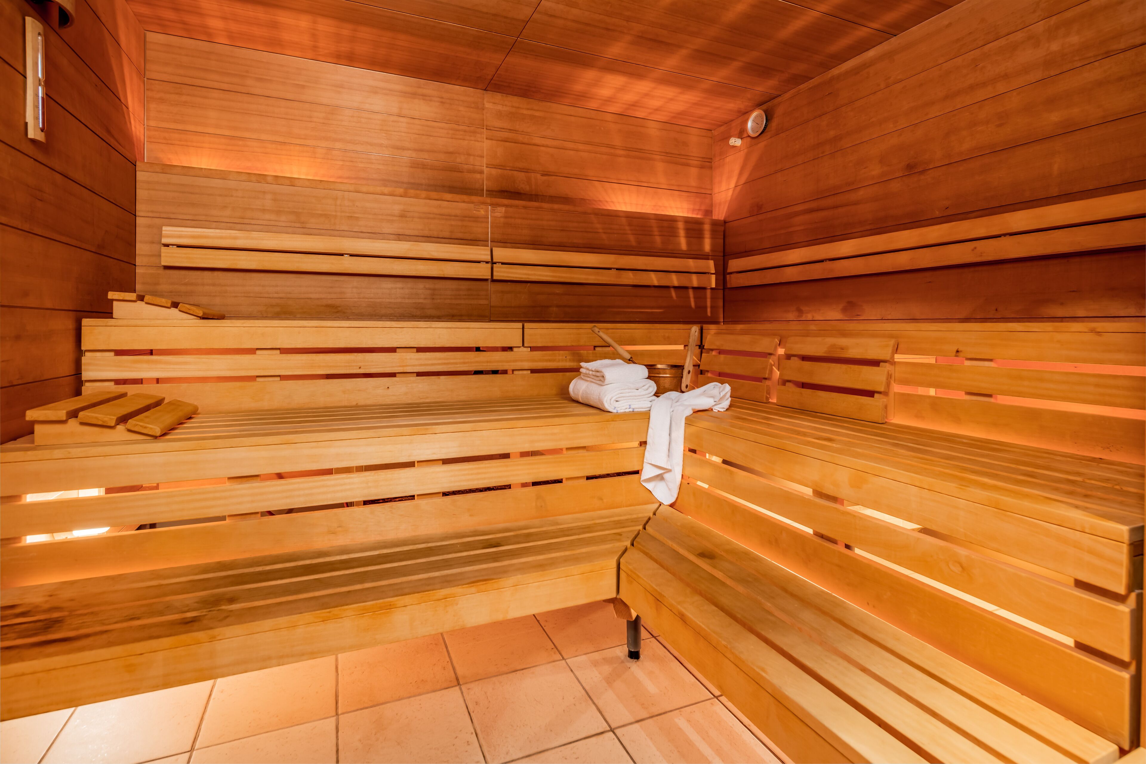 Een sauna met houten banken, een handdoek en een bank met een handdoek erop.