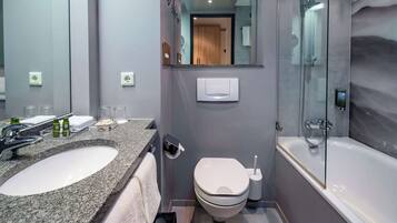 Ein modernes Badezimmer mit einem Waschbecken aus Granit, einer Toilette und einer Duschkabine.