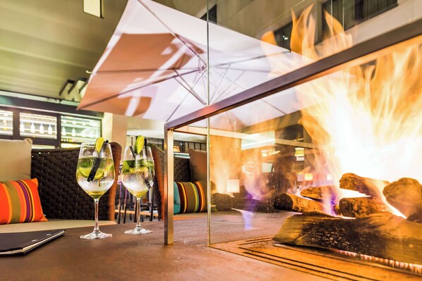 A table with two glasses of a clear beverage, a tablet, and a glass umbrella. - Park Plaza Trier (Trier)