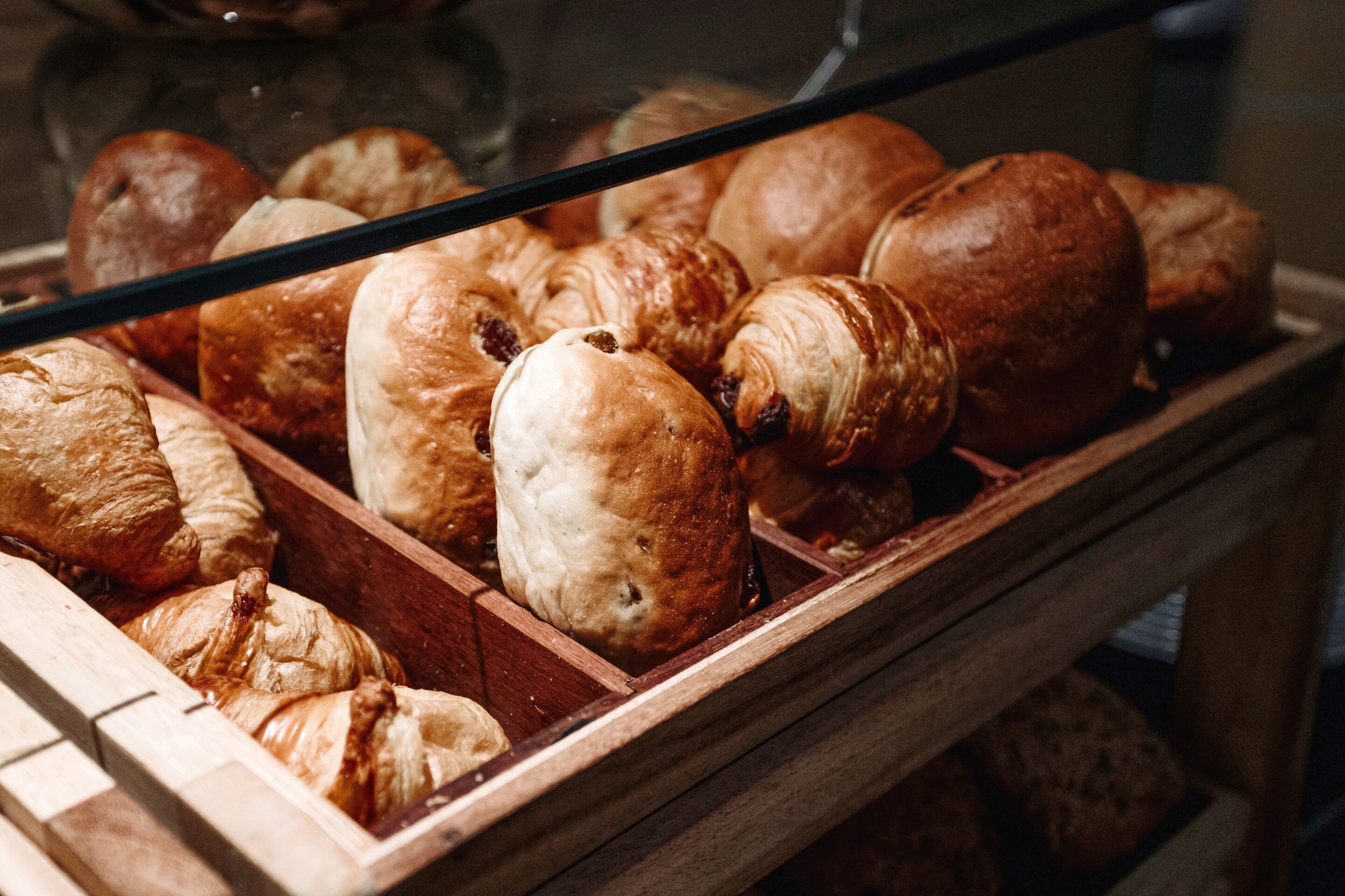 A display case with various baked goods, including croissants and other pastries.