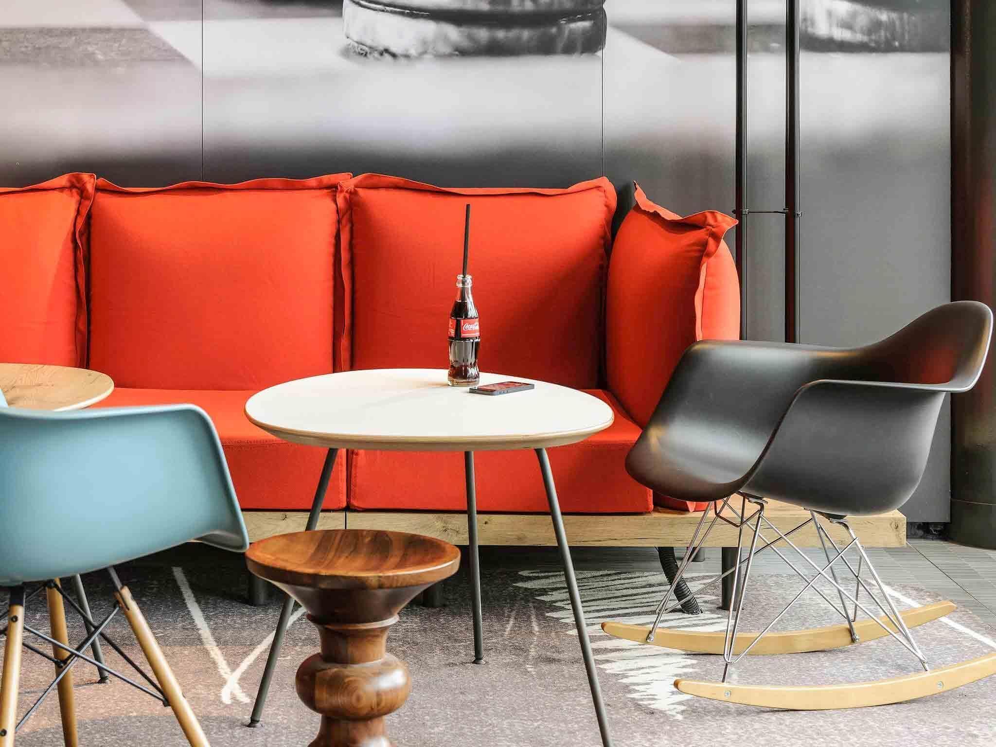 A modern seating area with a red sofa, a round table, and two chairs.