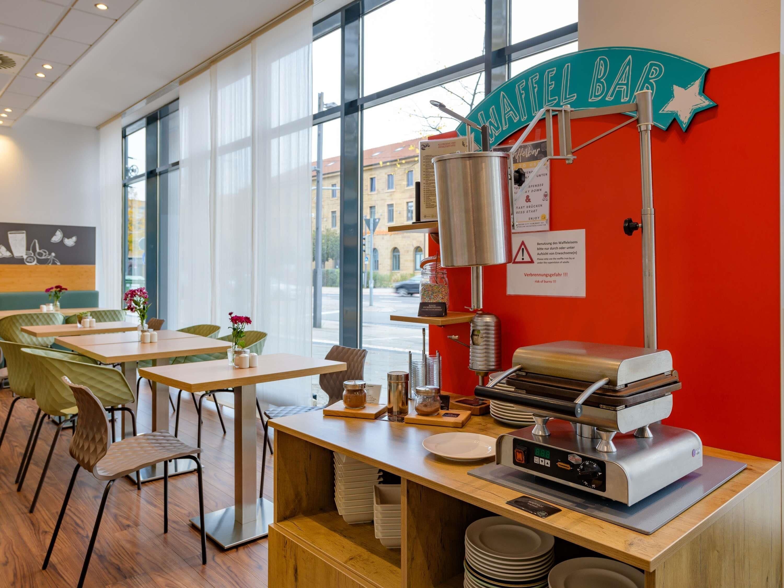 A cafe interior with a waffle bar, seating area, and a view of the street outside.
