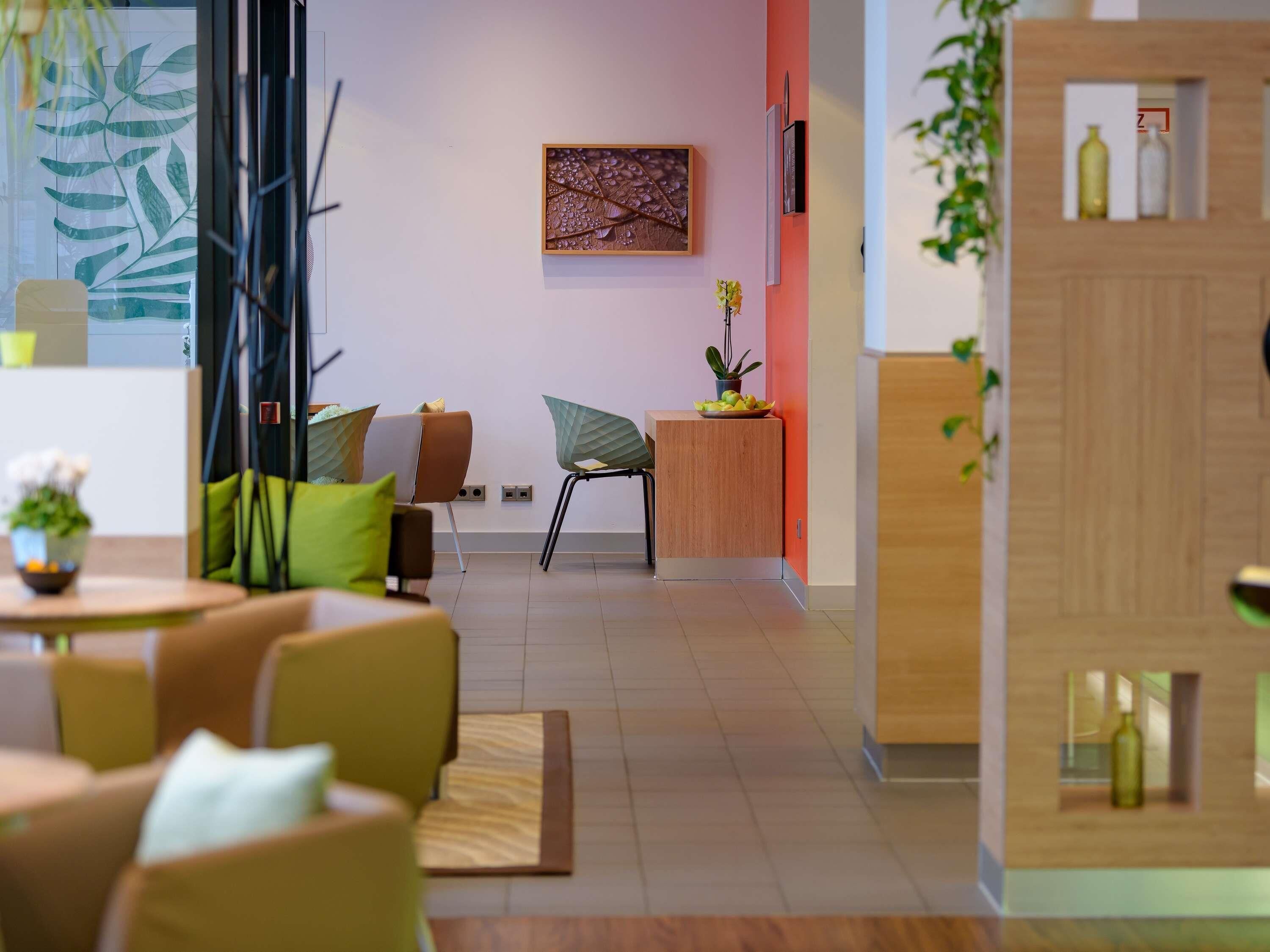 A modern interior with a seating area, a wooden desk, and a wall-mounted artwork.