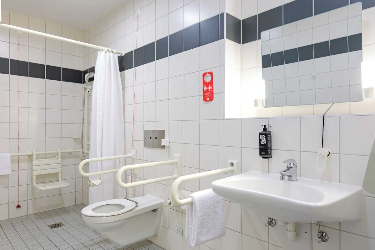 Ein modernes Badezimmer mit Toilette, Waschbecken und Duschbereich.