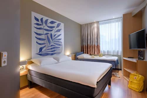 Biancheria da letto ipoallergenica, una scrivania, tende oscuranti