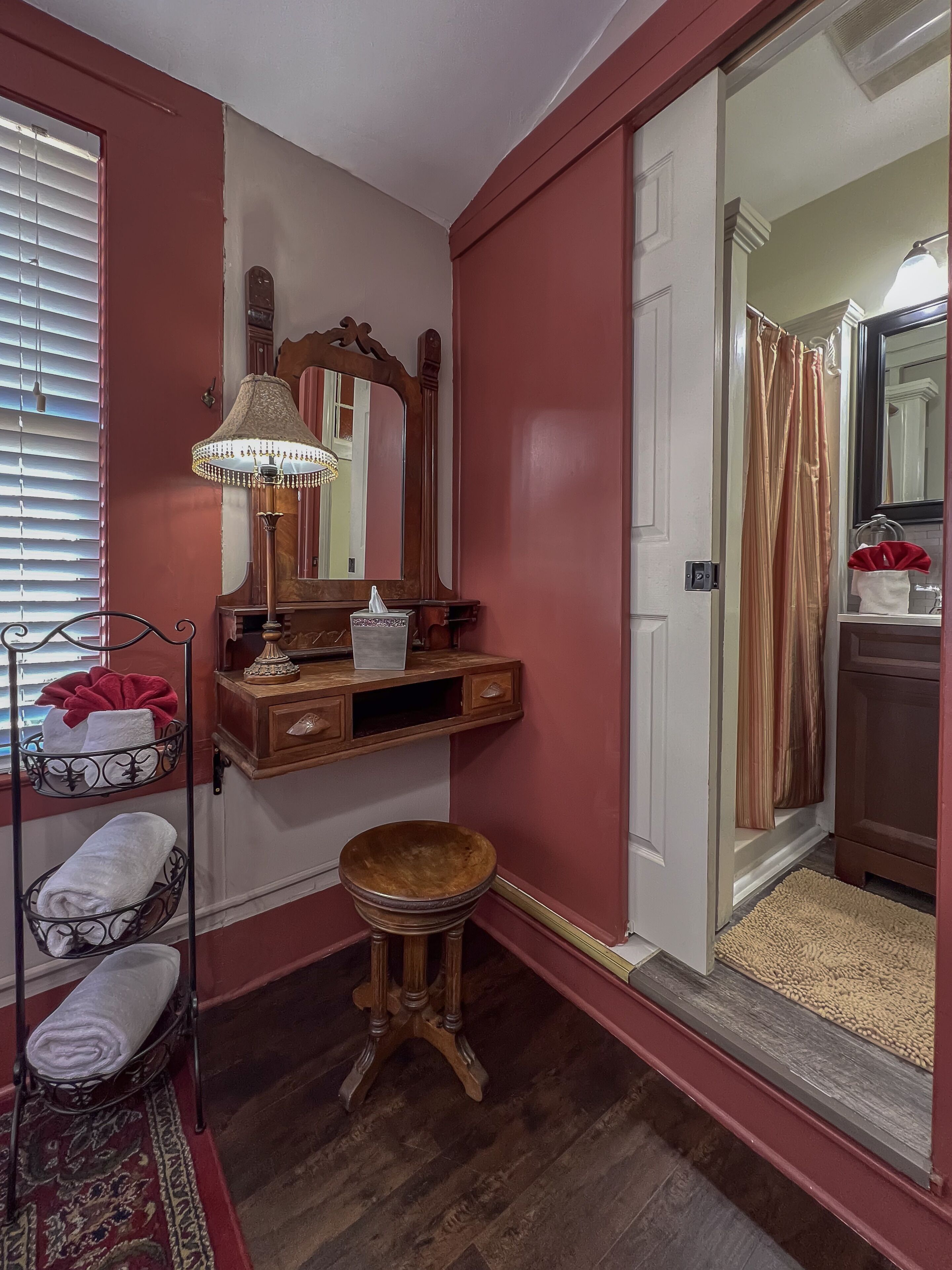 A bathroom with a wooden vanity, a mirror, a towel rack, and a shower curtain.