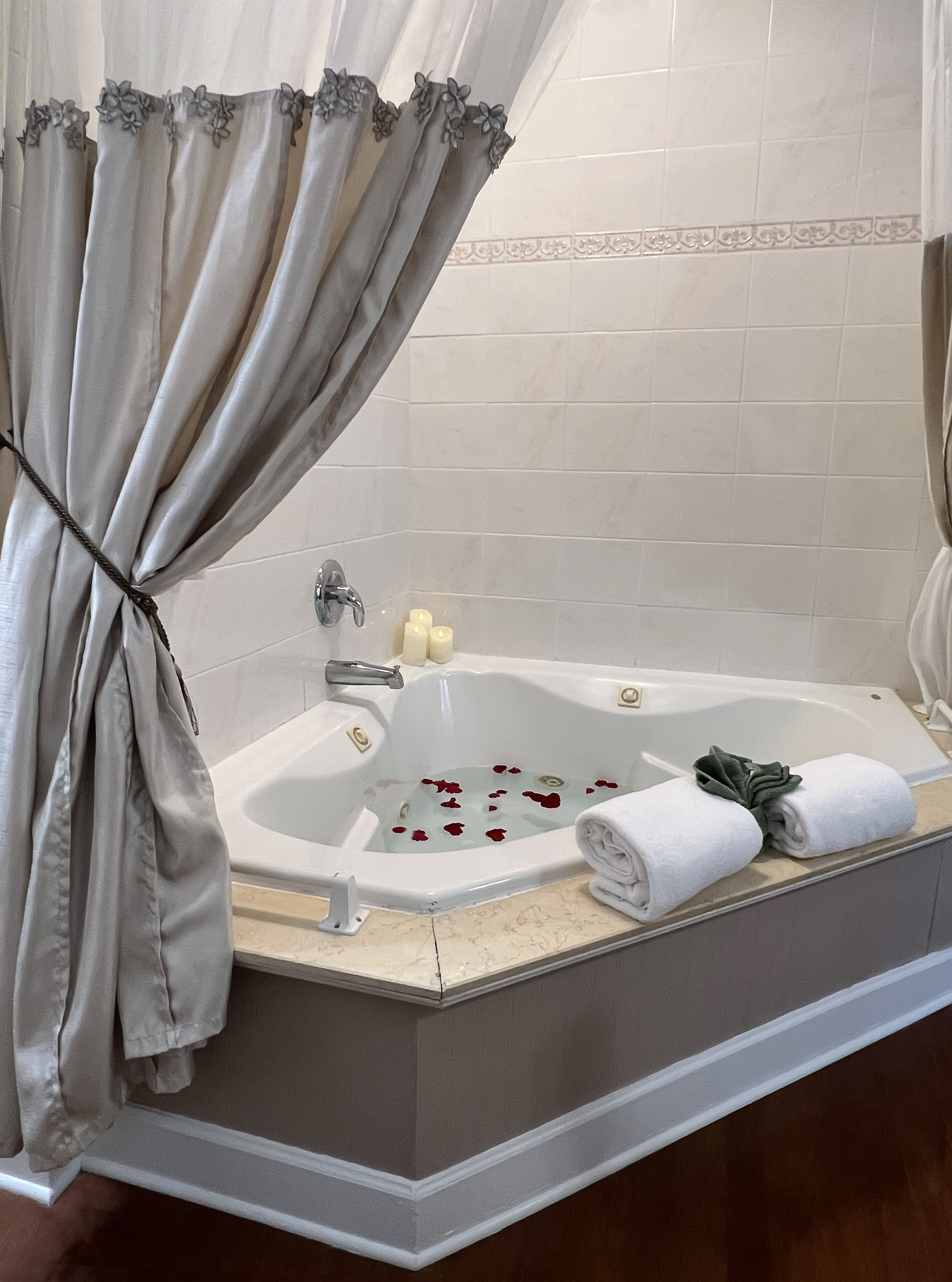 Een badkamer met een bad, een handdoek en een gordijn.