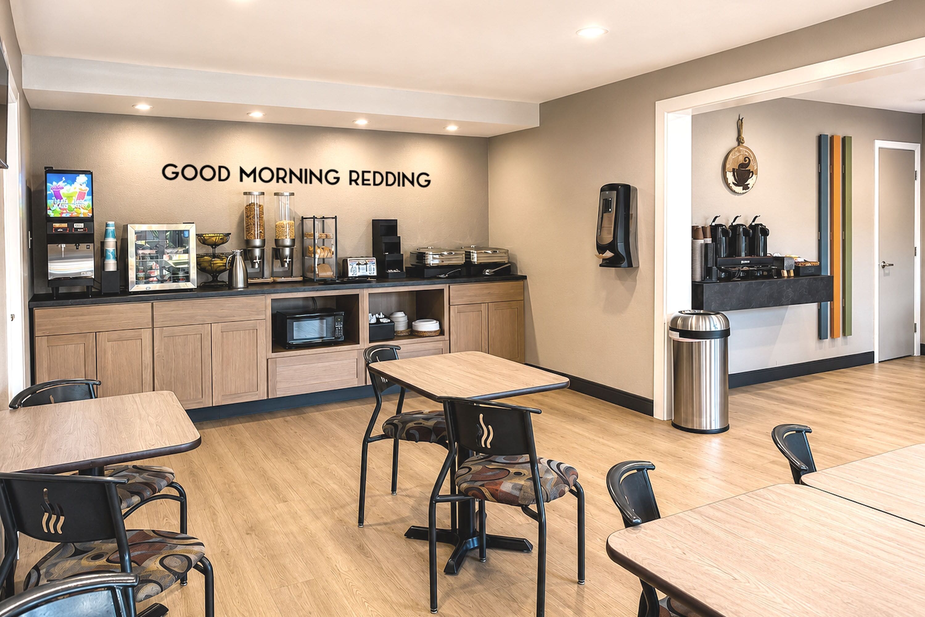 A breakfast area with a counter, seating, and a wall sign reading 'GOOD MORNING REDDING'.
