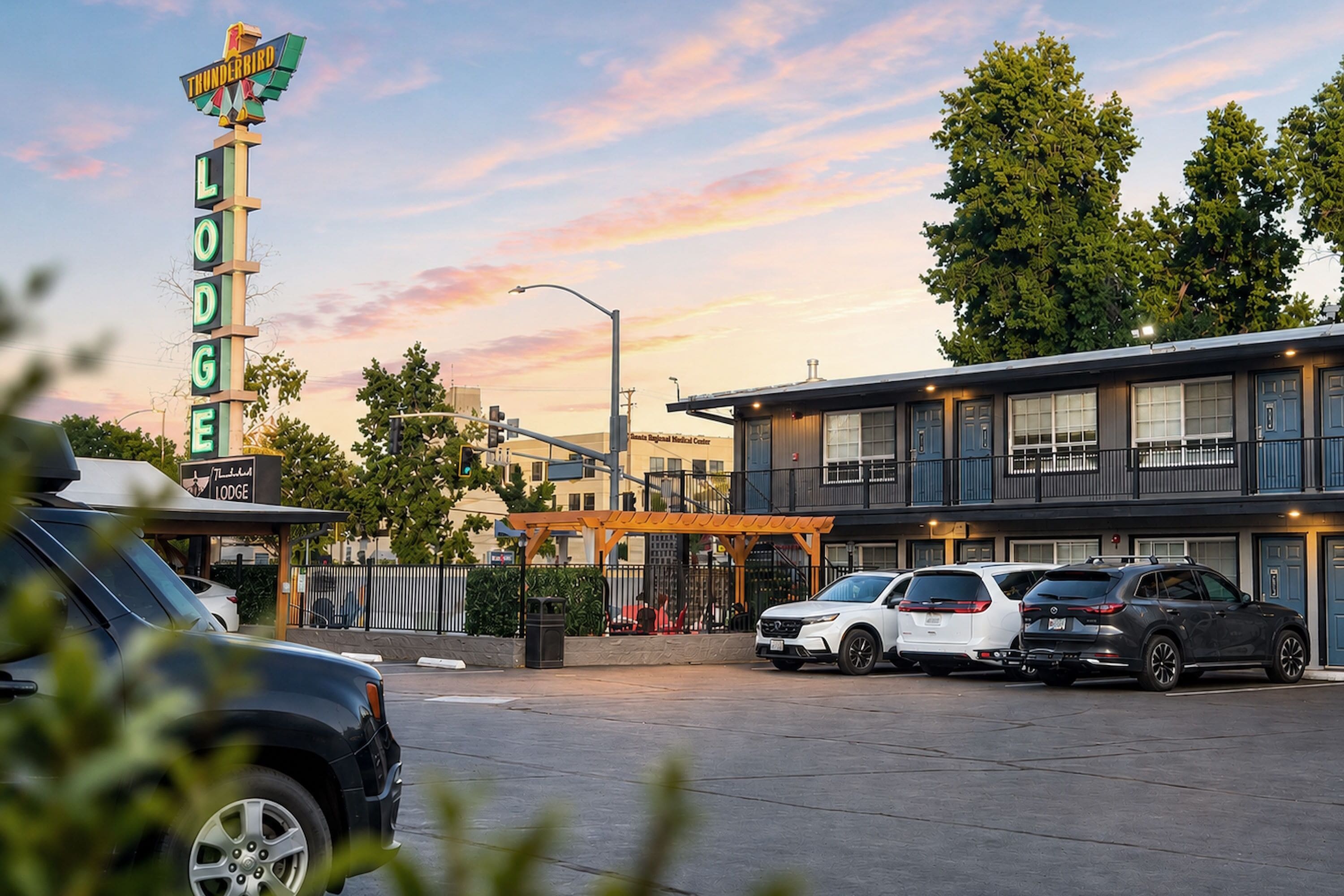 Ein Parkplatz mit einem Gebäude, an dem 'Thunderbird Lodge' steht, und einem medizinischen Zentrum im Hintergrund.