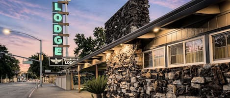 A stone facade building with a neon sign reading 'Thunderbird Lodge.'