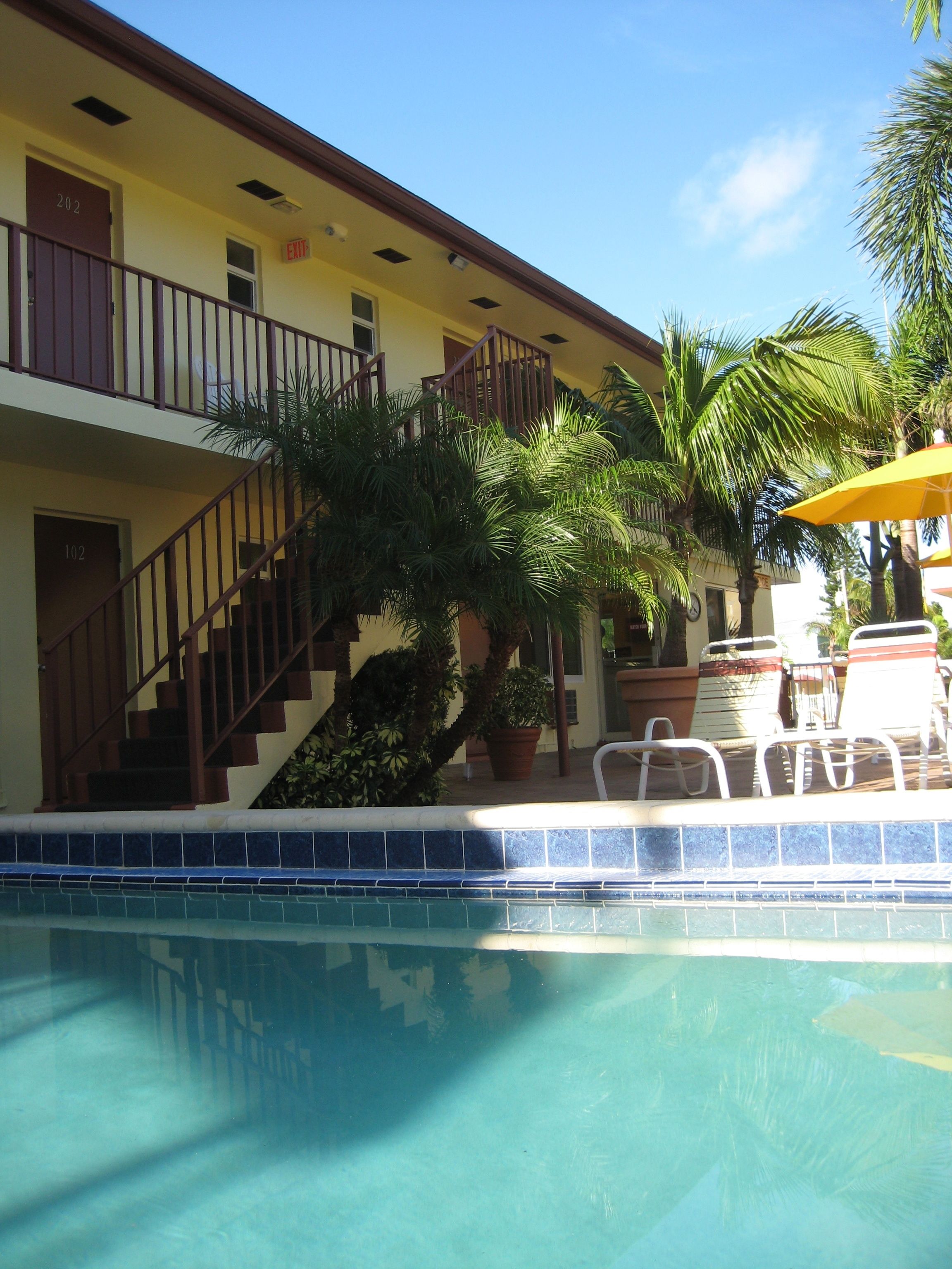 A hotel with a pool, a staircase, and outdoor seating.