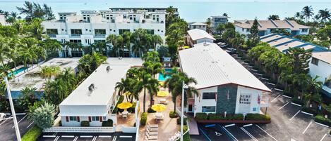 A resort with a pool, outdoor seating, and a view of the ocean.