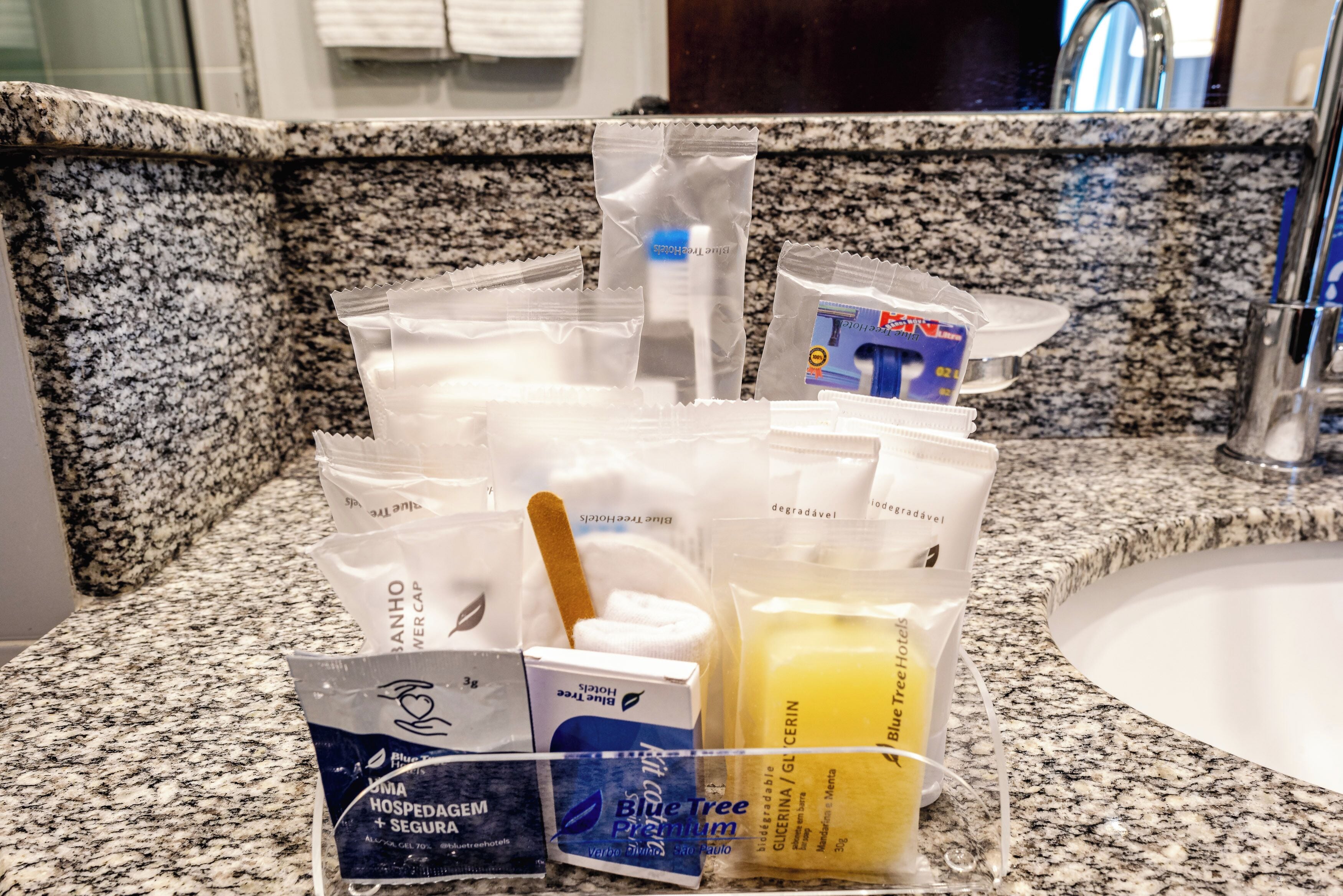 A bathroom counter with toiletries including a toothbrush, toothpaste, and a soap dispenser.