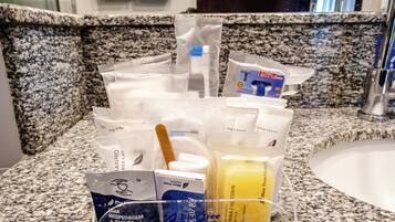 A bathroom counter with toiletries including a toothbrush, toothpaste, and a soap dispenser.