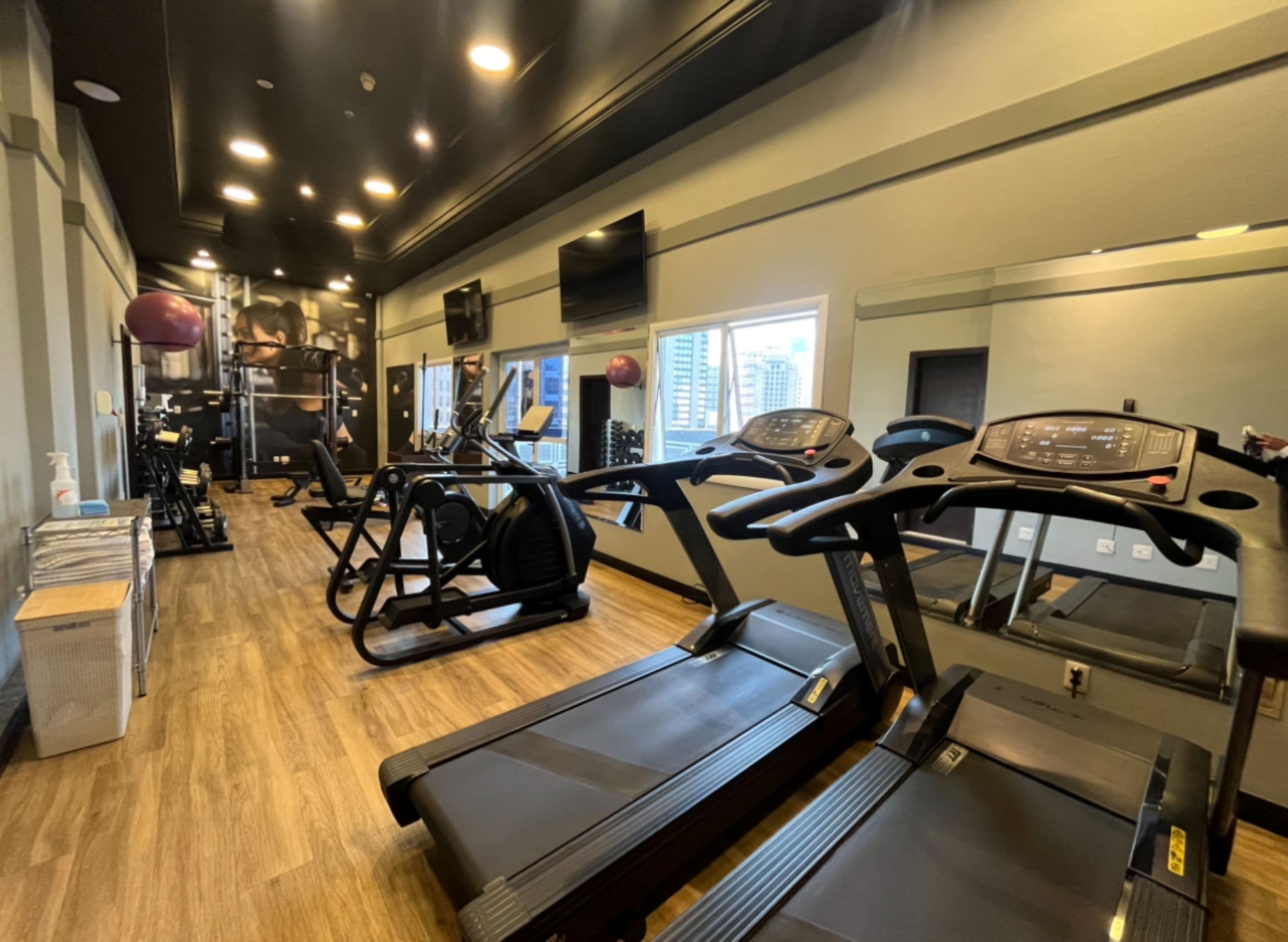 A gym with treadmills, elliptical machines, and weightlifting equipment.