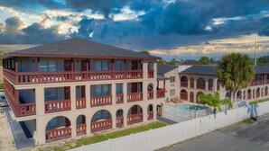 A multi-story hotel with balconies, a swimming pool, and a view of the surrounding area. - Sevilla Inn - Near Medieval Times (Kissimmee)