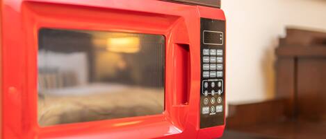 A red microwave with a digital display and a keypad.