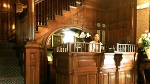 A grand staircase with wooden railings and a patterned carpet. - Redstone Inn And Suites (Dubuque)