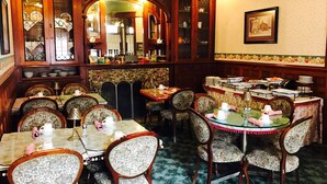 A dining area with multiple tables and chairs, a mirror, and a buffet setup. - Redstone Inn And Suites (Dubuque)