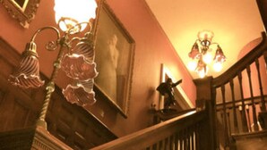 A grand staircase with ornate railings and a chandelier. - Redstone Inn And Suites (Dubuque)