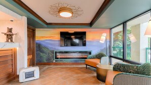 A room with a fireplace, seating area, and a view of the outdoors. - Quality Inn Near the Island Pigeon Forge (Pigeon Forge)