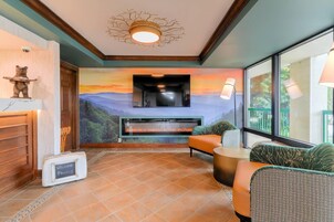 A room with a fireplace, seating area, and a view of the outdoors.