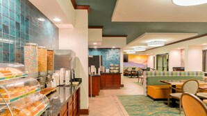 A hotel lobby with a buffet area, seating, and a view of a mountain. - Quality Inn Near the Island Pigeon Forge (Pigeon Forge)