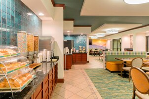 A hotel lobby with a buffet area, seating, and a view of a mountain.