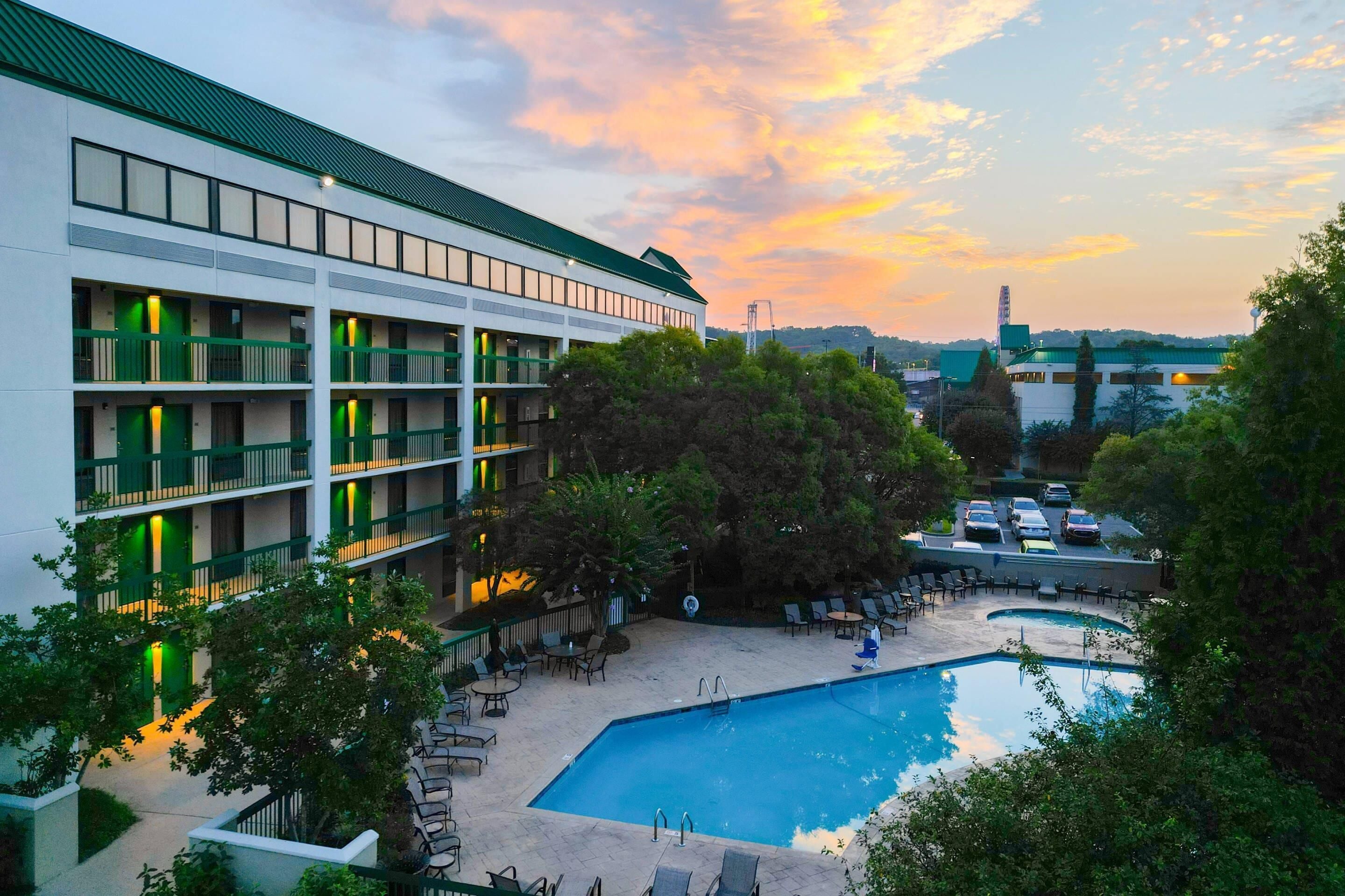A hotel with multiple floors, outdoor swimming pool, and lounge area.