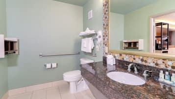 Un baño con inodoro, lavabo, toallero y secador de manos.