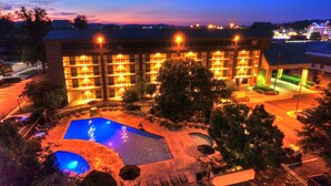 A hotel with multiple floors, outdoor swimming pool, and well-lit surroundings. - Quality Inn Near the Island Pigeon Forge (Pigeon Forge)
