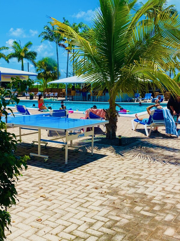 Una piscina al aire libre, sillones reclinables de piscina