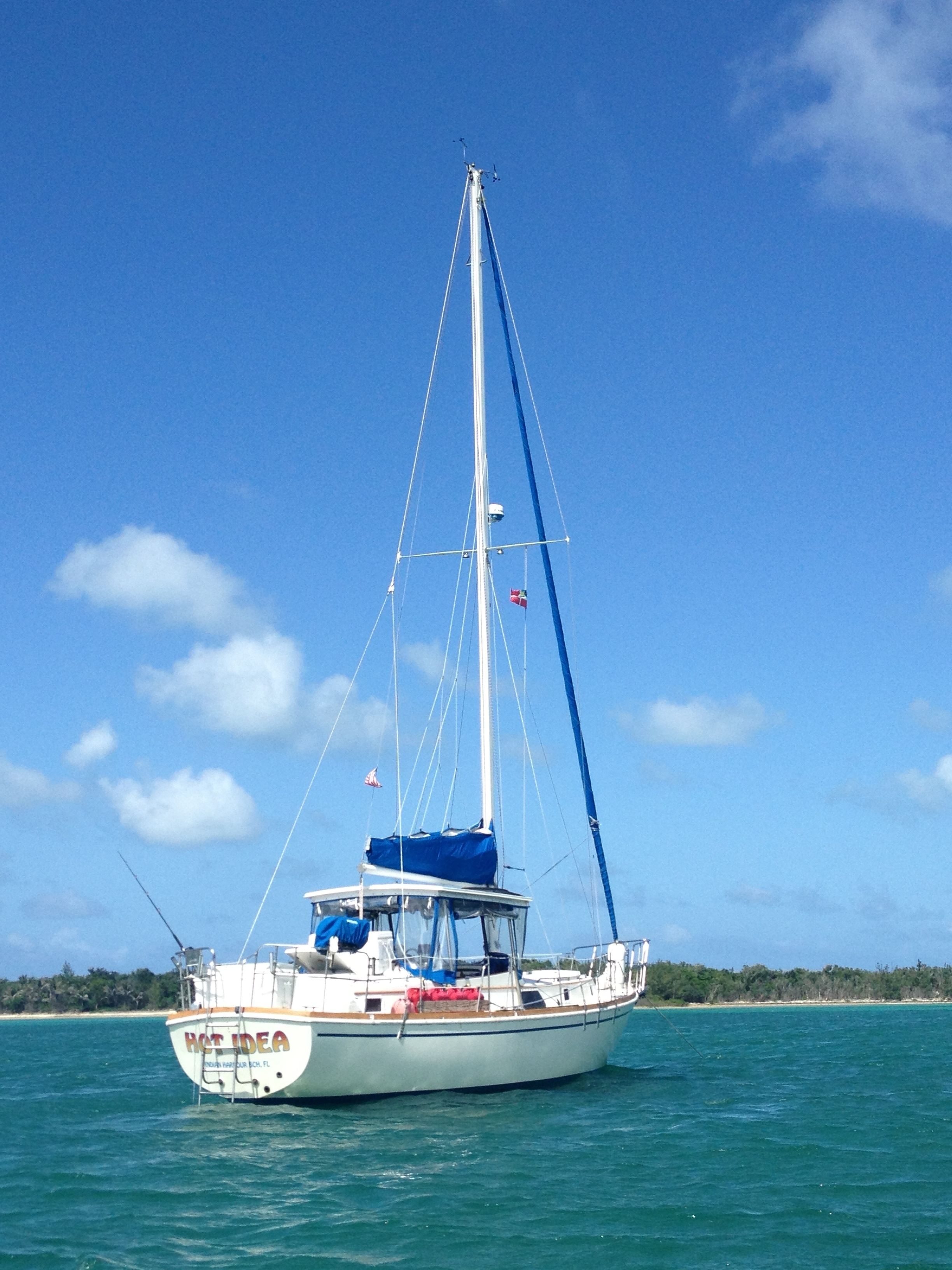 A sailboat with a cabin and a cabin window, sailing on a body of water.