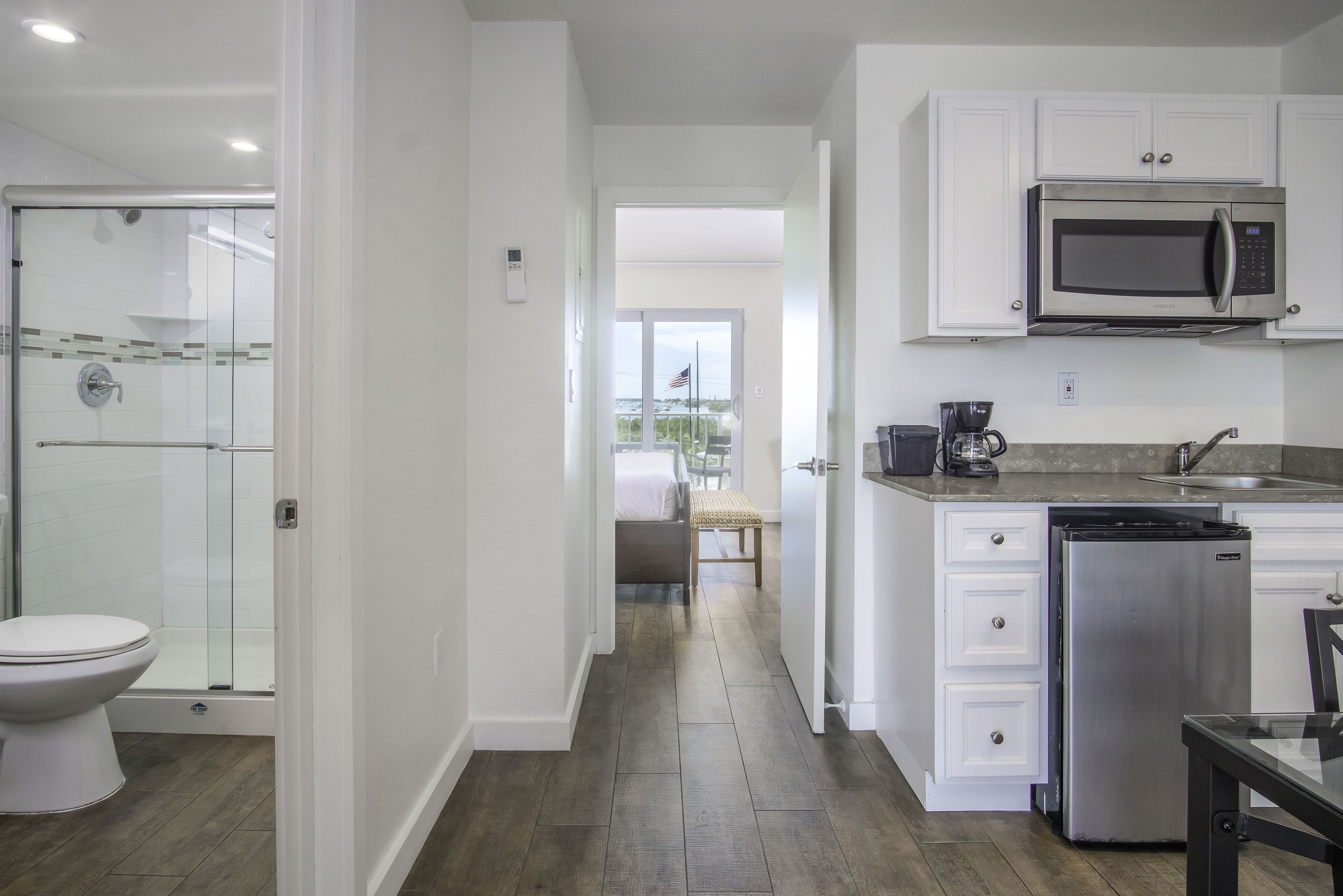A modern kitchen with white cabinets, a stainless steel refrigerator, and a built-in microwave.