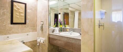 A bathroom with a bathtub, sink, and mirror.