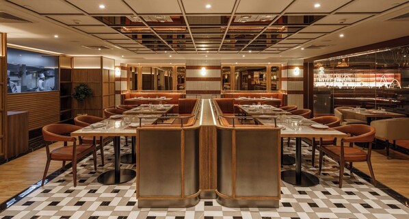 Un restaurante con una isla central, varias mesas y cabinas.